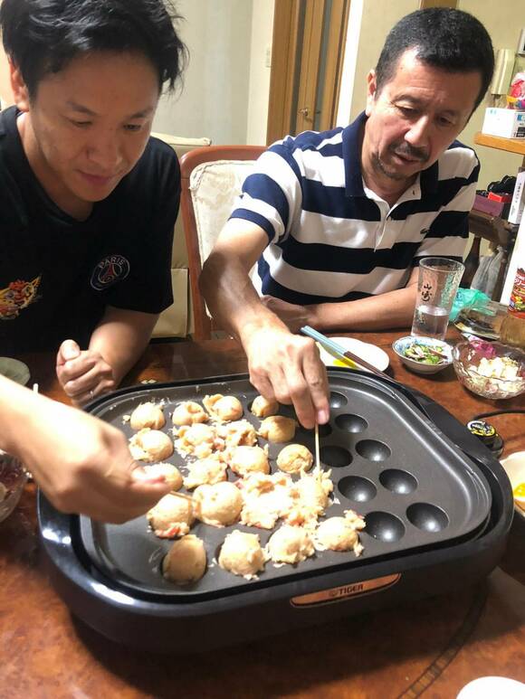タコ焼き機まわりに男性2人