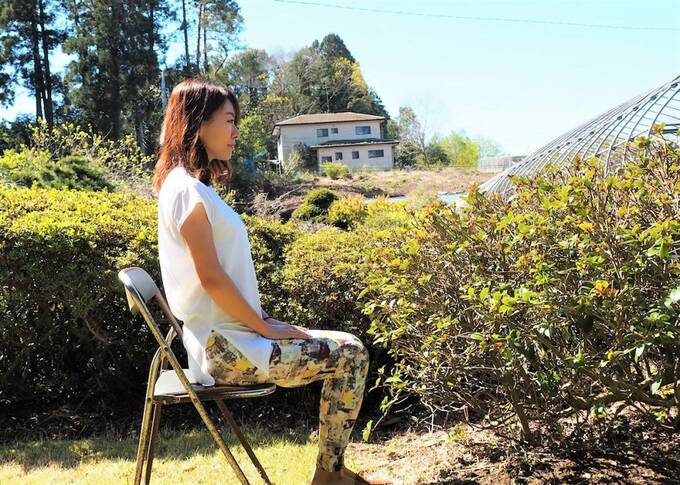 イスに座って背筋を伸ばす女性