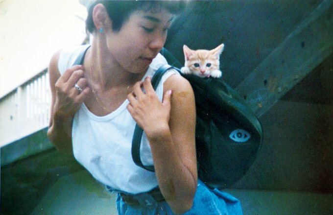 化け子さんの背負うリュックから子猫が顔を出す