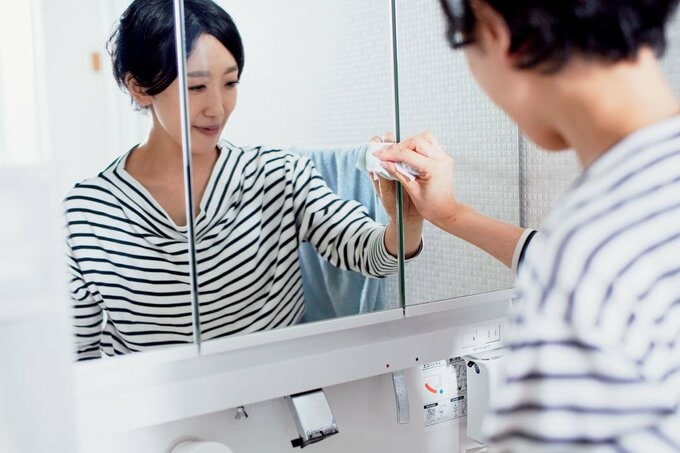 鏡の掃除をする女性