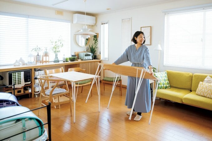 水色のワンピースを着た女性がテーブルを運ぶ様子