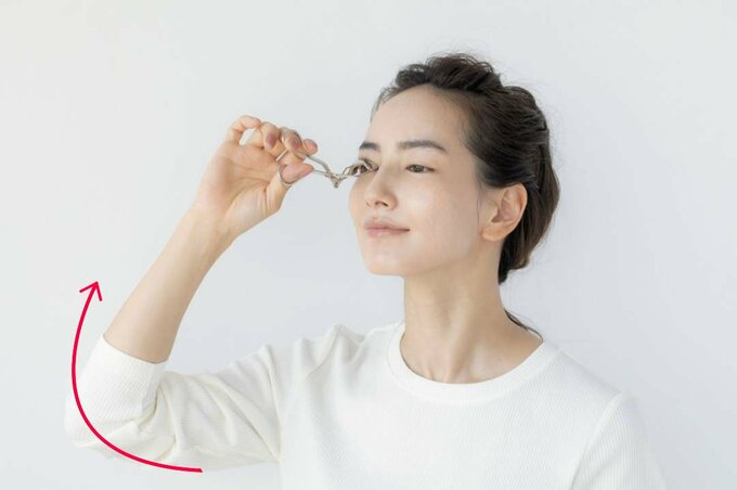 カーラーでまつげをカチカチと小刻みにはさんで上げる