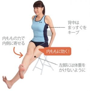 上げた右脚を内側に寄せて20秒キープする女性