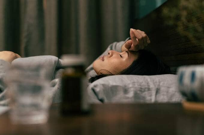 頭に手を置いて眠る女性