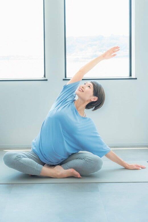 斜め上に手を伸ばし脇腹を伸ばすヨガのポーズ