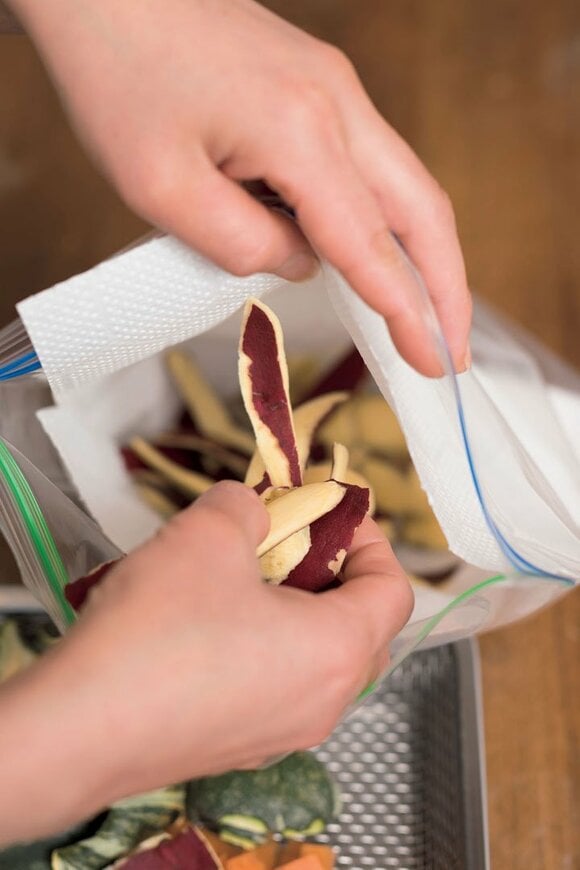 ペーパータオルが入った保存袋に野菜の皮を入れる