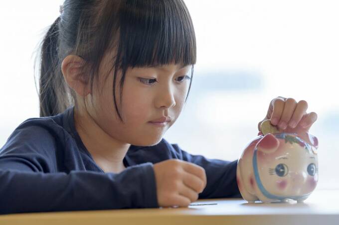 豚の貯金箱と女の子