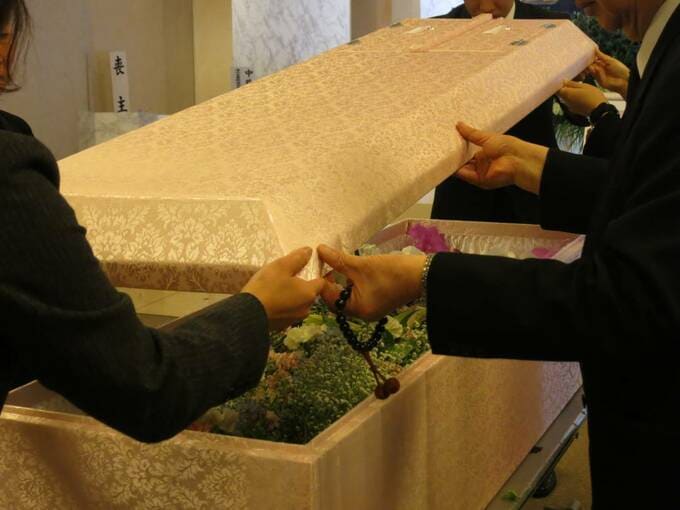 棺のふたを持ち上げている様子