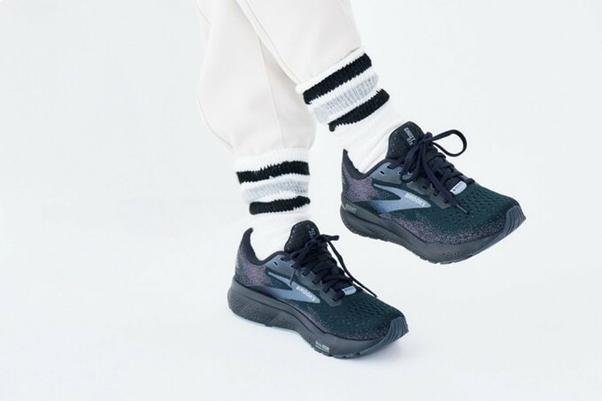 黒スニーカーと白のラインソックスを履いた足元