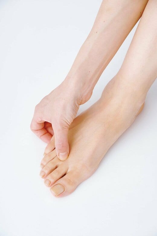 足の指のツボ「内庭」を押す人