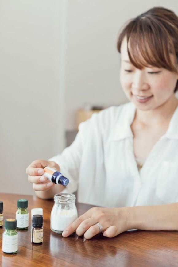 プリンなどのあきビンに重曹を入れ、エッセンシャルオイル数滴たらして芳香剤を作っている様子