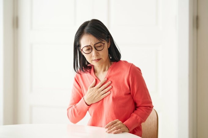 胸を手で押さえる女性のイメージ画像