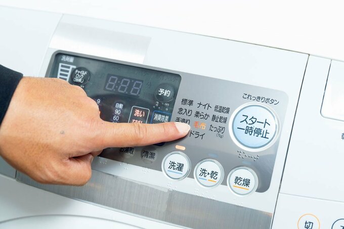 洗濯機ボタンを指さす様子