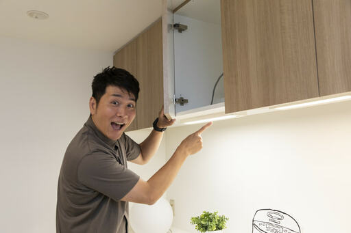 棚の下を指差す男性