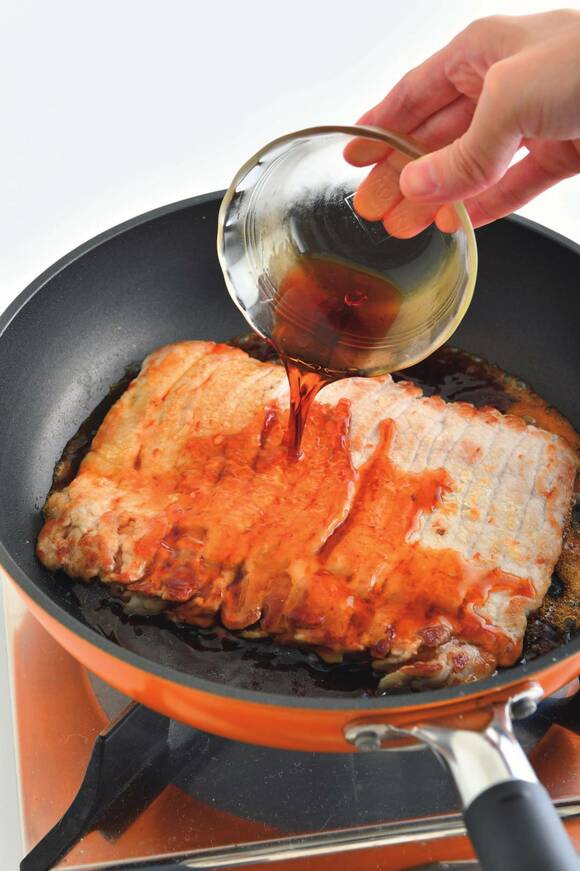 タレを回しかけて焼きからめる様子