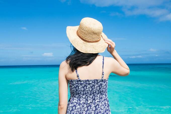 海を前に帽子をかぶった女性