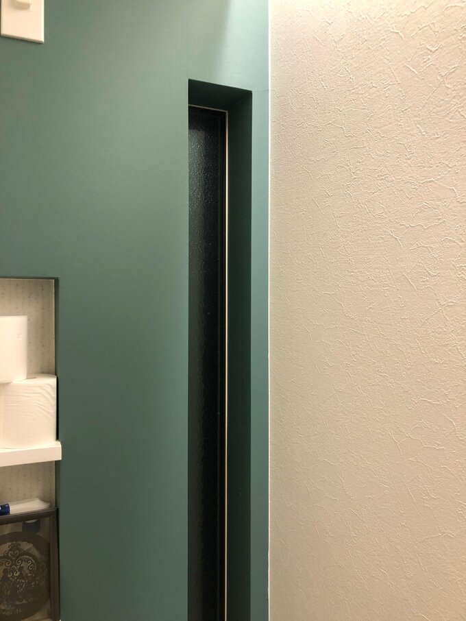細い縦長の窓とトイレットペーパー収納