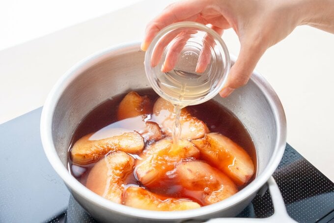 鍋にレモン汁を加えている