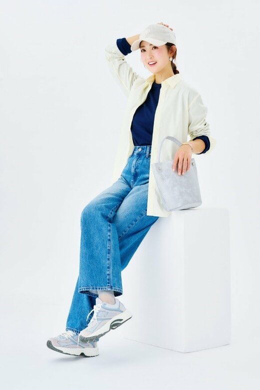 頭に手を当て足を組んで座る女性