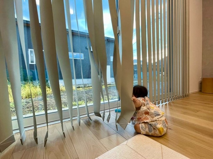 バーチカルブラインドで遊ぶ子ども