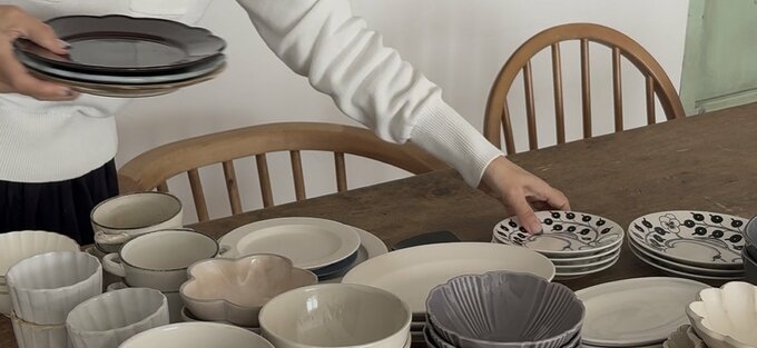 ダイニングテーブルに大量の食器を並べている