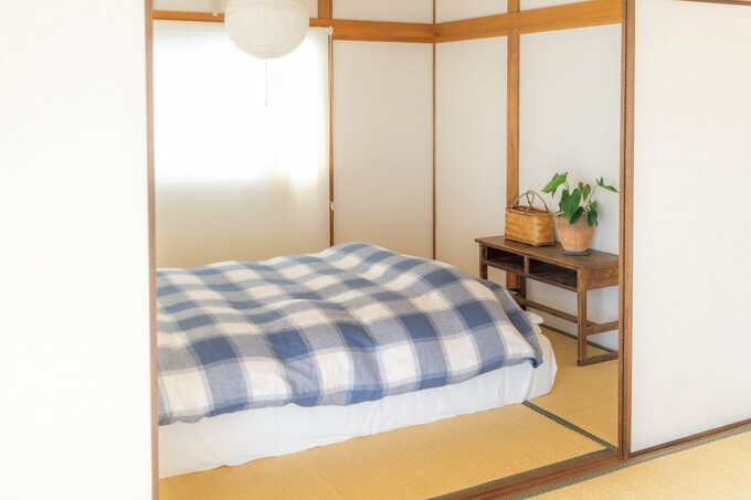白と青のチェック柄のカバーがかけられたベッド