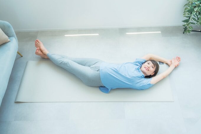 ヨガでバナナのポーズをする女性