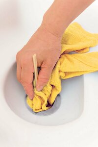 タオルに割り箸をはさみ排水口の汚れを取る