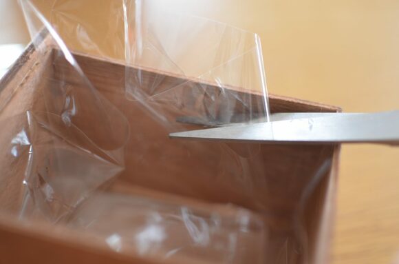 2.ウッドボックスにナイロンを敷き、セロハンテープでとめます。