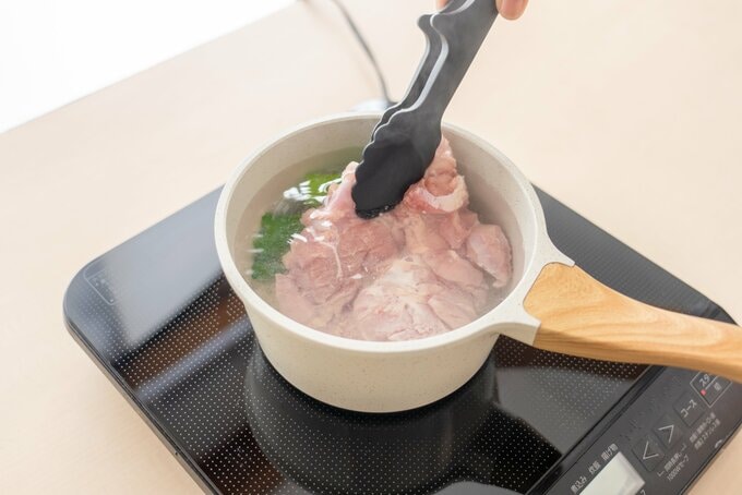 沸騰した鍋に鶏肉を入れる