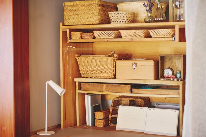 パソコンデスクやサイドテーブルをラックにして物を収納した押し入れ