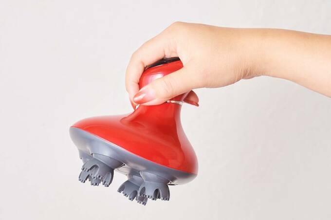 頭皮マッサージャーを持つ様子