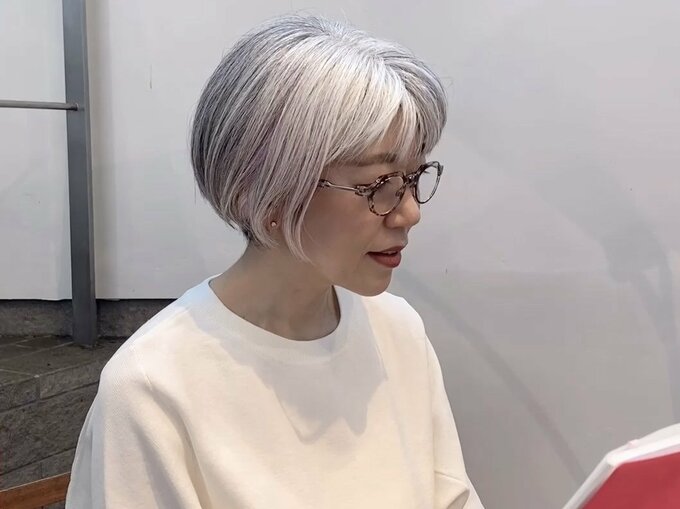 老眼鏡をかける朝倉さん