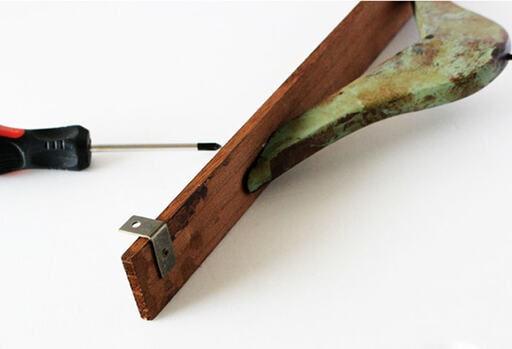 木材の両端に、壁掛け用の吊り金具を取り付ける