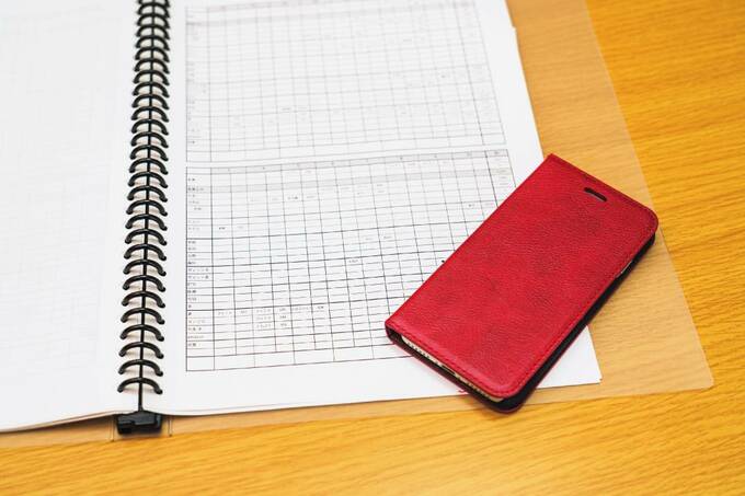 出力した家計簿とスマホ