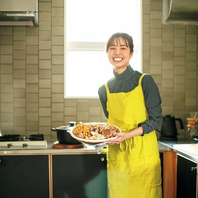 エプロンつけて料理もっている女性