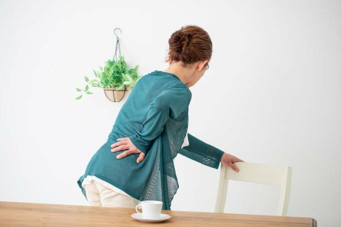 腰をおさえる女性