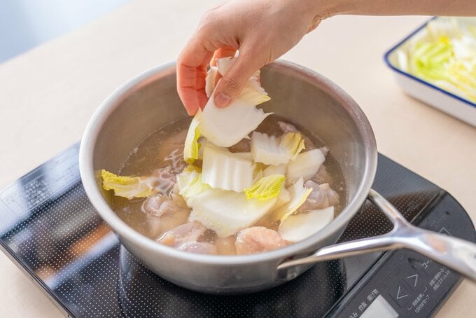 白菜と鶏肉を鍋で煮込む様子