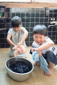 たらいで洗濯して手で水を絞る