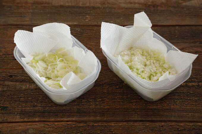 キッチンペーパーを敷いた保存容器に入れた小口切りとみじん切りをした長ネギ