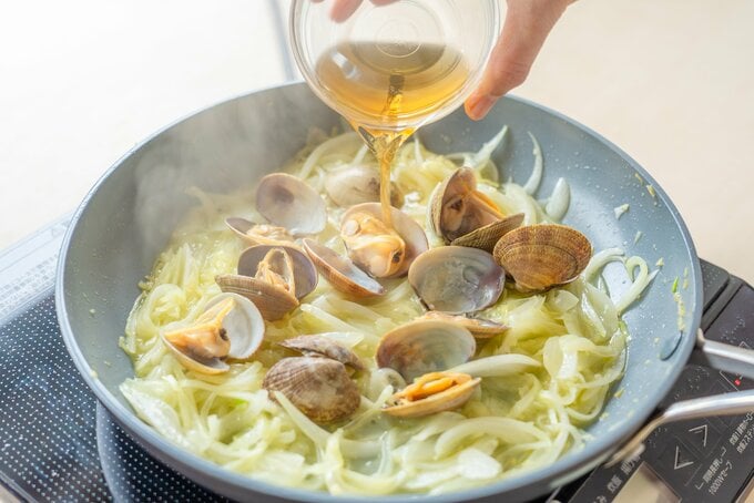 フライパンにあさりと白ワインを入れている
