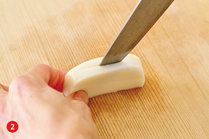 白かまぼこの背の真ん中に切り込みを入れる様子