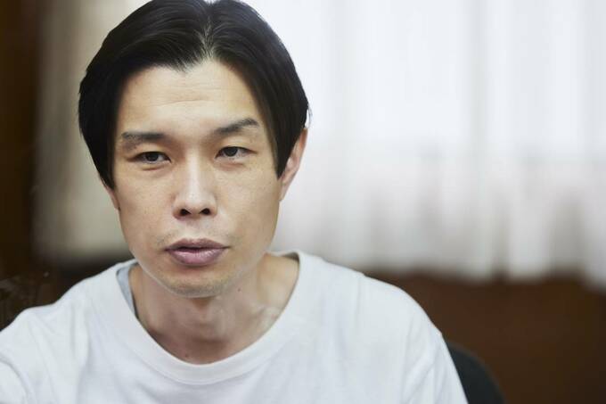 インタビューに答える正面向きの男性