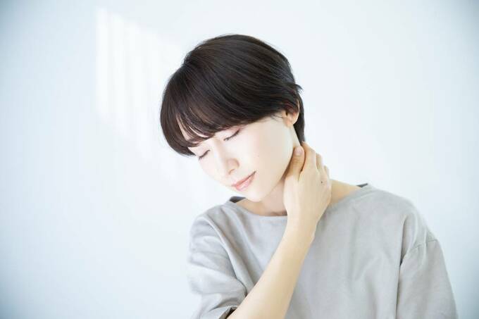 首をさわる女性