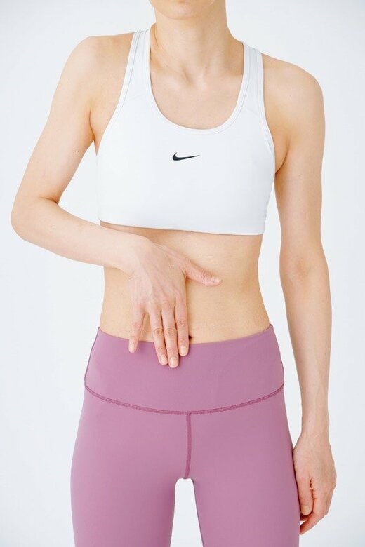 おへその横に指3本を当てる