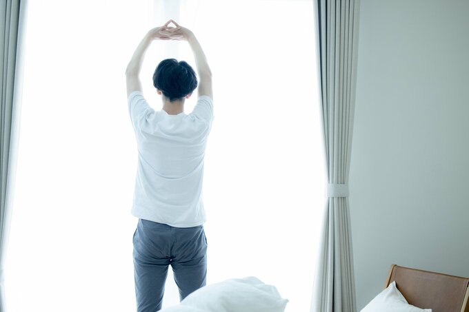 寝室で伸びる男性