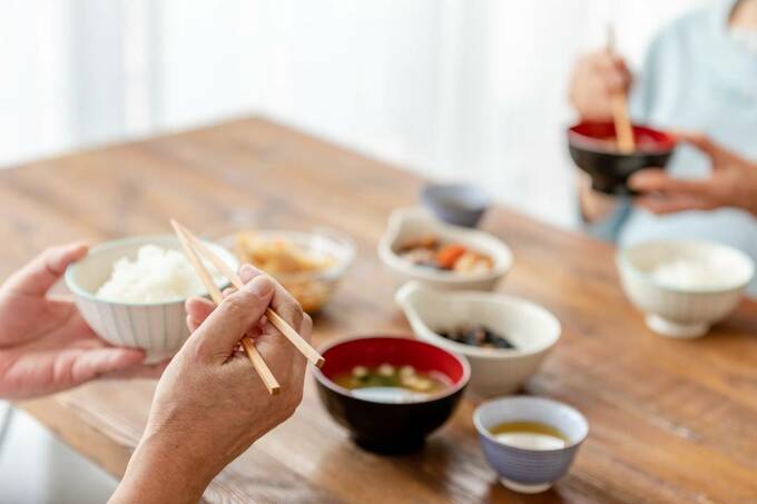 料理の前で茶碗を持つ様子