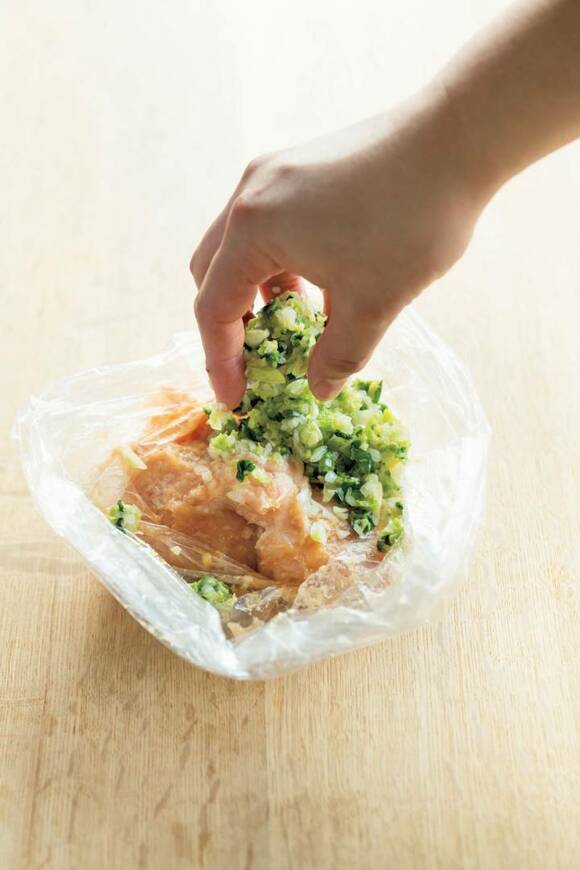 袋に鶏と白菜を入れる様子