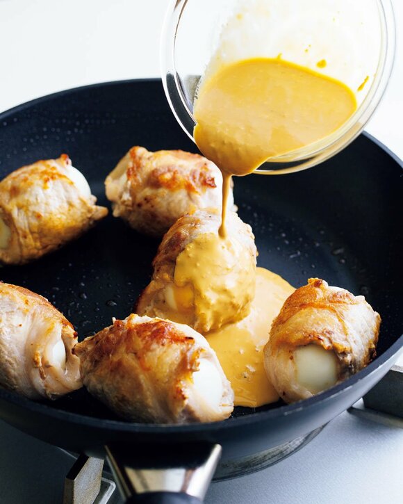 お肉があるフライパンにソースをかける様子