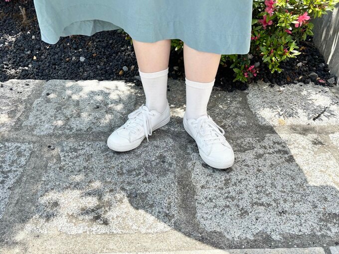 白い靴を履いた足元の写真
